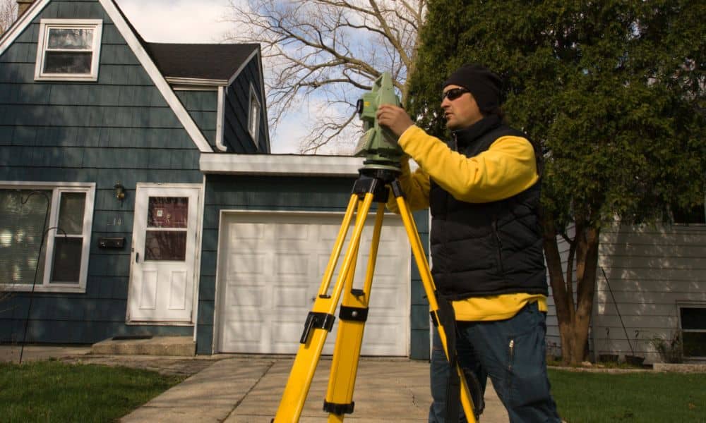 topographic surveys - Land surveyor conducting a topographic survey in front of a residential driveway in Los Angeles