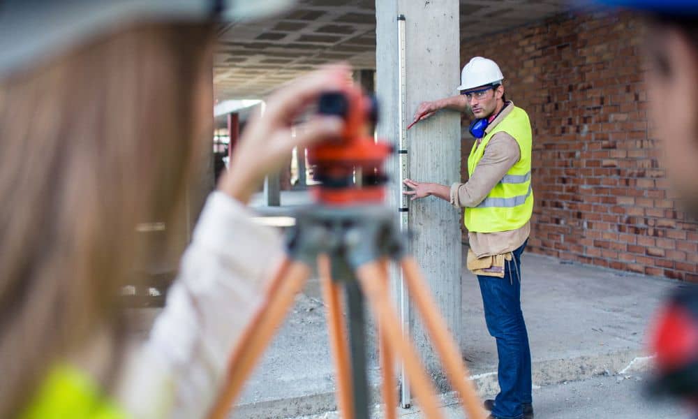 Construction surveyors measuring vertical alignment on a building site