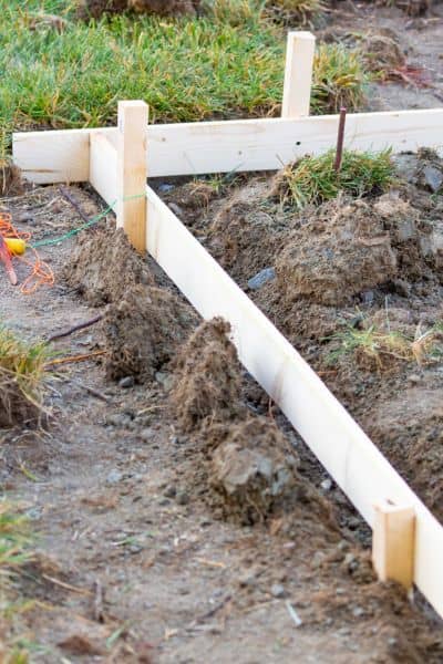 Wooden stakes and string lines marking boundaries on a property survey to show accurate land measurements