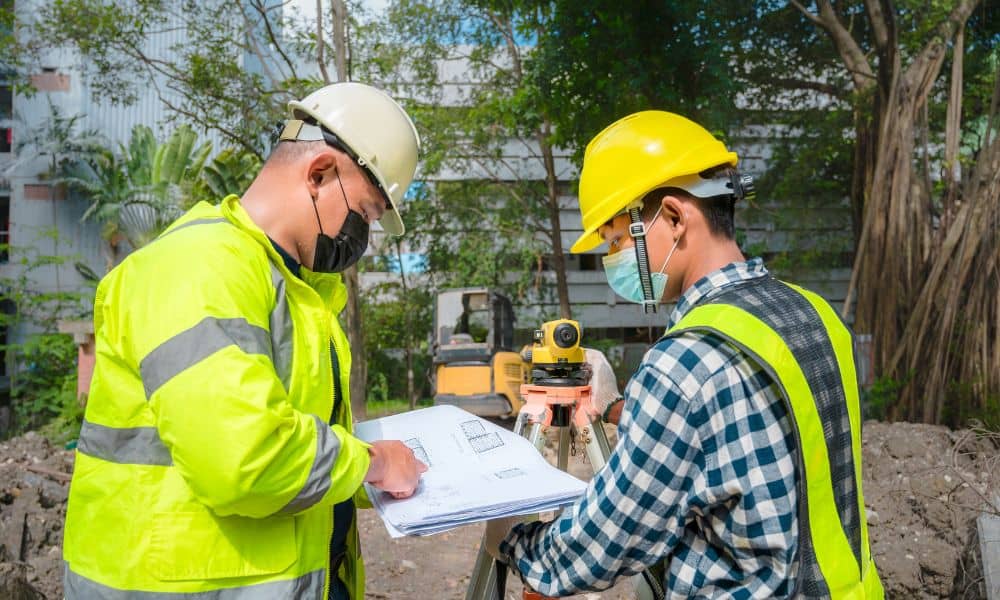 Surveyors reviewing a site plan during a due diligence survey before property development