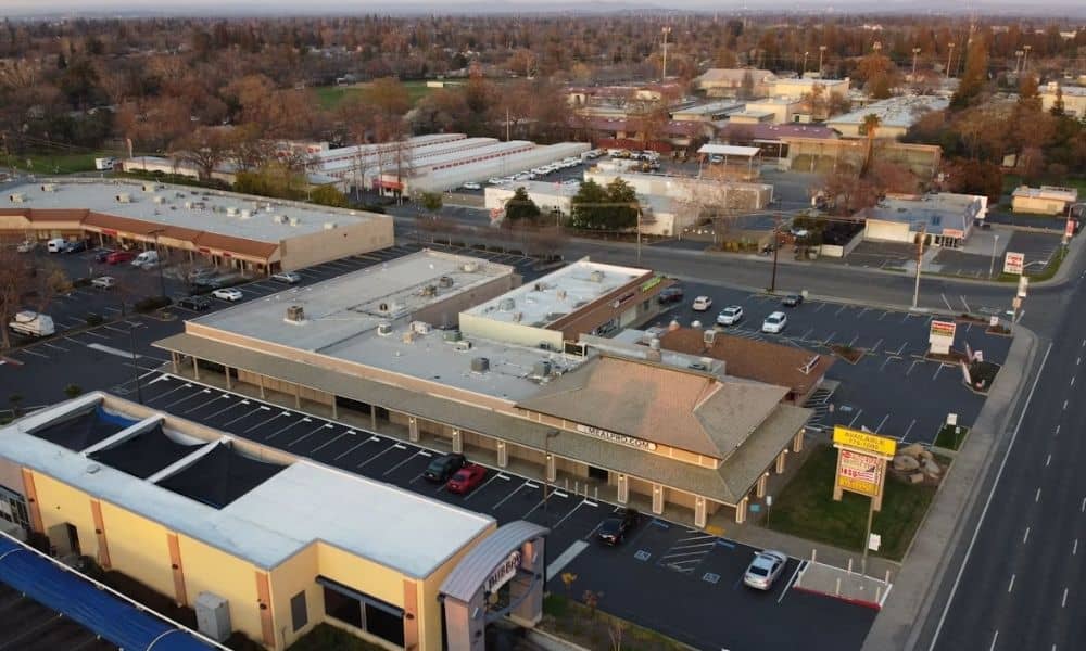 Aerial view of a shopping center and surrounding commercial properties being assessed for redevelopment through a due diligence survey