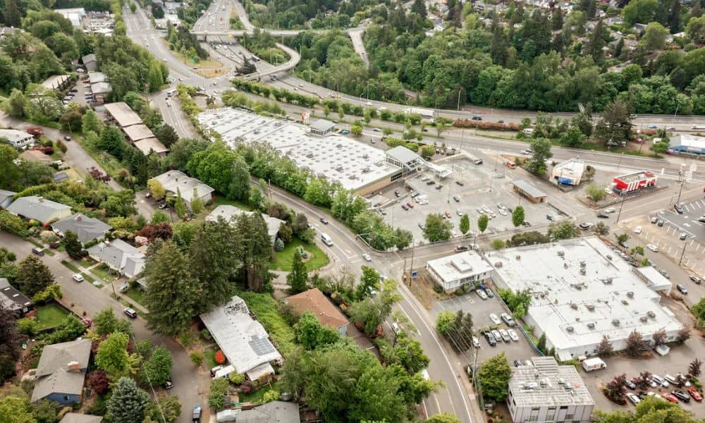 Aerial view of several commercial properties with shared parking areas, access roads, and surrounding buildings